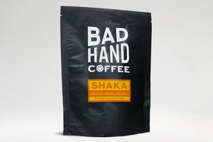 Buy Shaka, our house espresso/filter blend - taste notes: chocolate, orange and molasses. Hand roasted and fresh to order. Available as whole bean or ground to your brew method. These bags are 100% paper and home compostable.