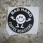 Bad Hand Coffee sticker pack, contains five waterproof stickers of various styles. Sticker one, round, with white text on a black background.